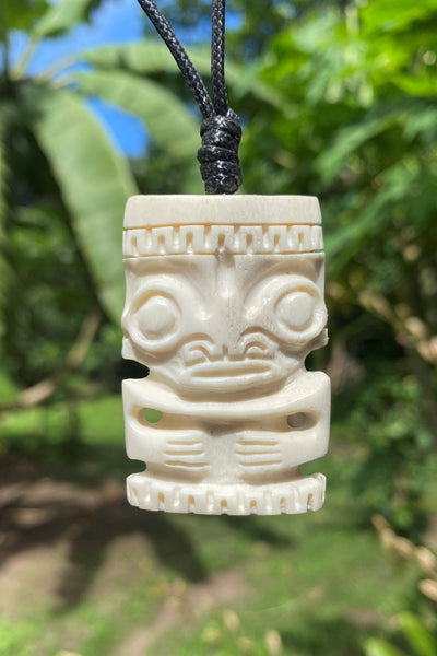 Carved tiki pendant on a cord.