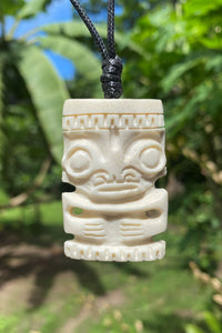 Carved tiki pendant on a cord.